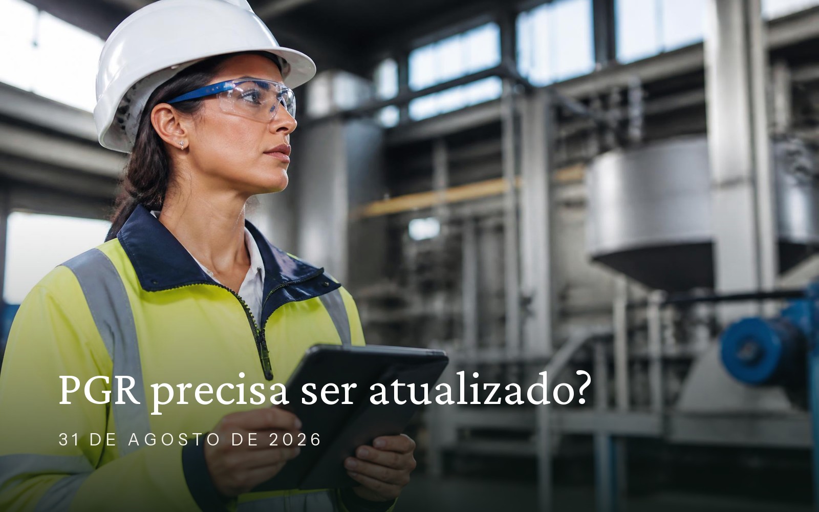 Profissional de Segurança do Trabalho analisando documentos em tablet dentro de ambiente industrial organizado